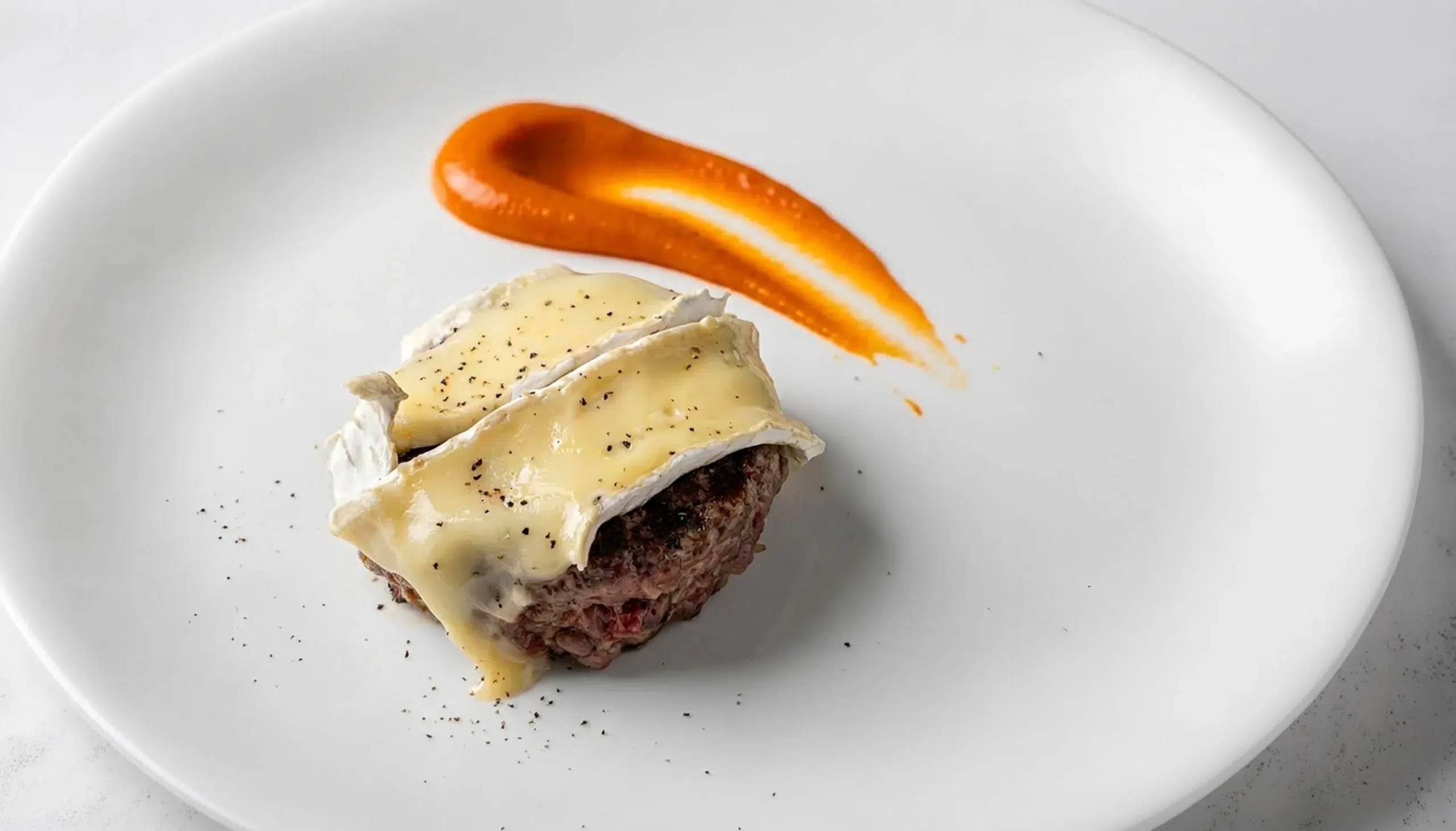 una hamburguesa con queso brie, acompañada con salsa burger